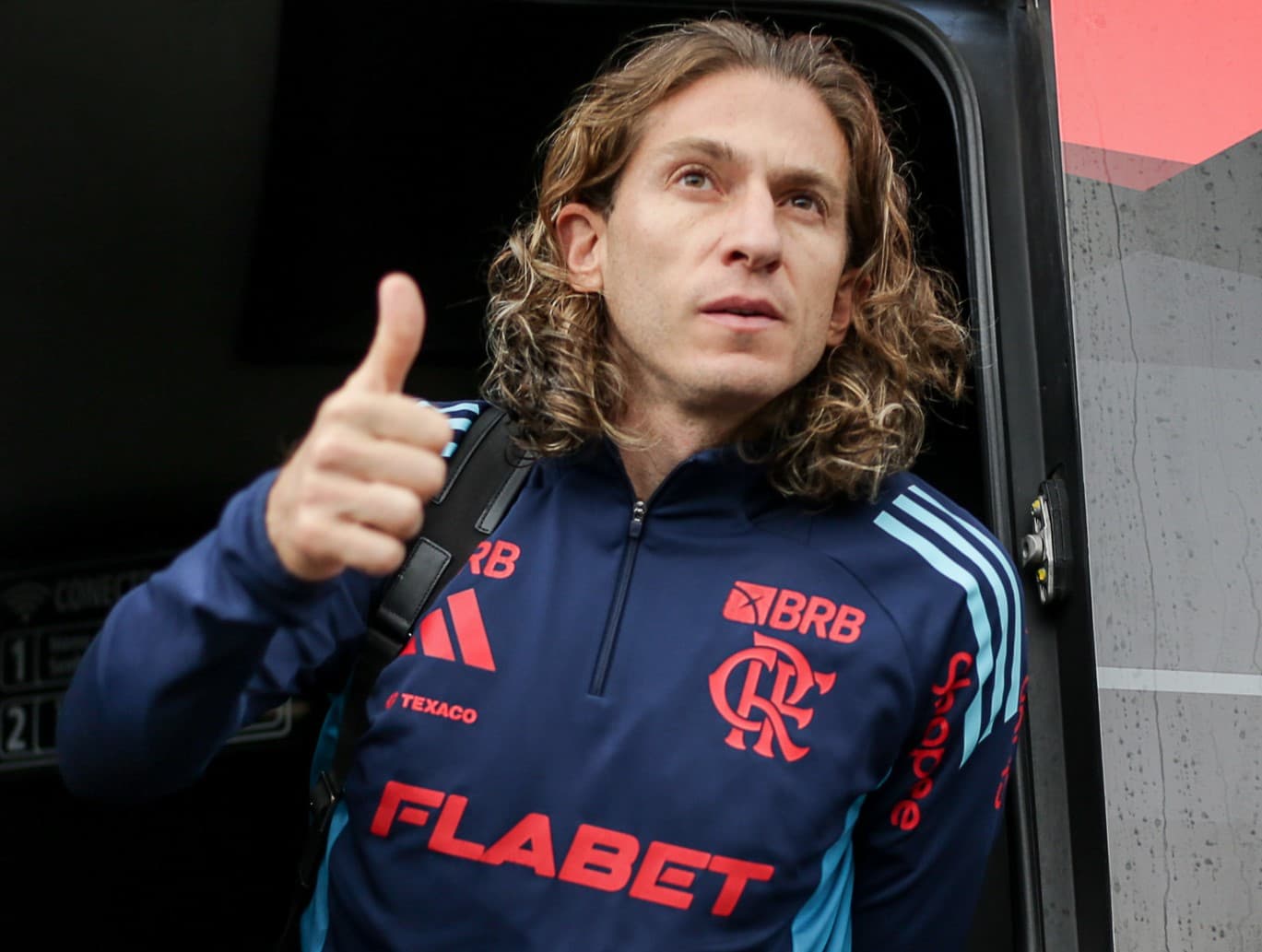 Filipe Luís manda um "joia" ao descer do ônibus durante o embarque para Belo Horizonte