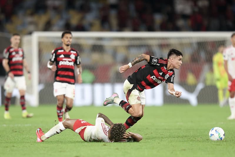 Luiz Araújo arranca com a bola enquanto Wesley observa caído