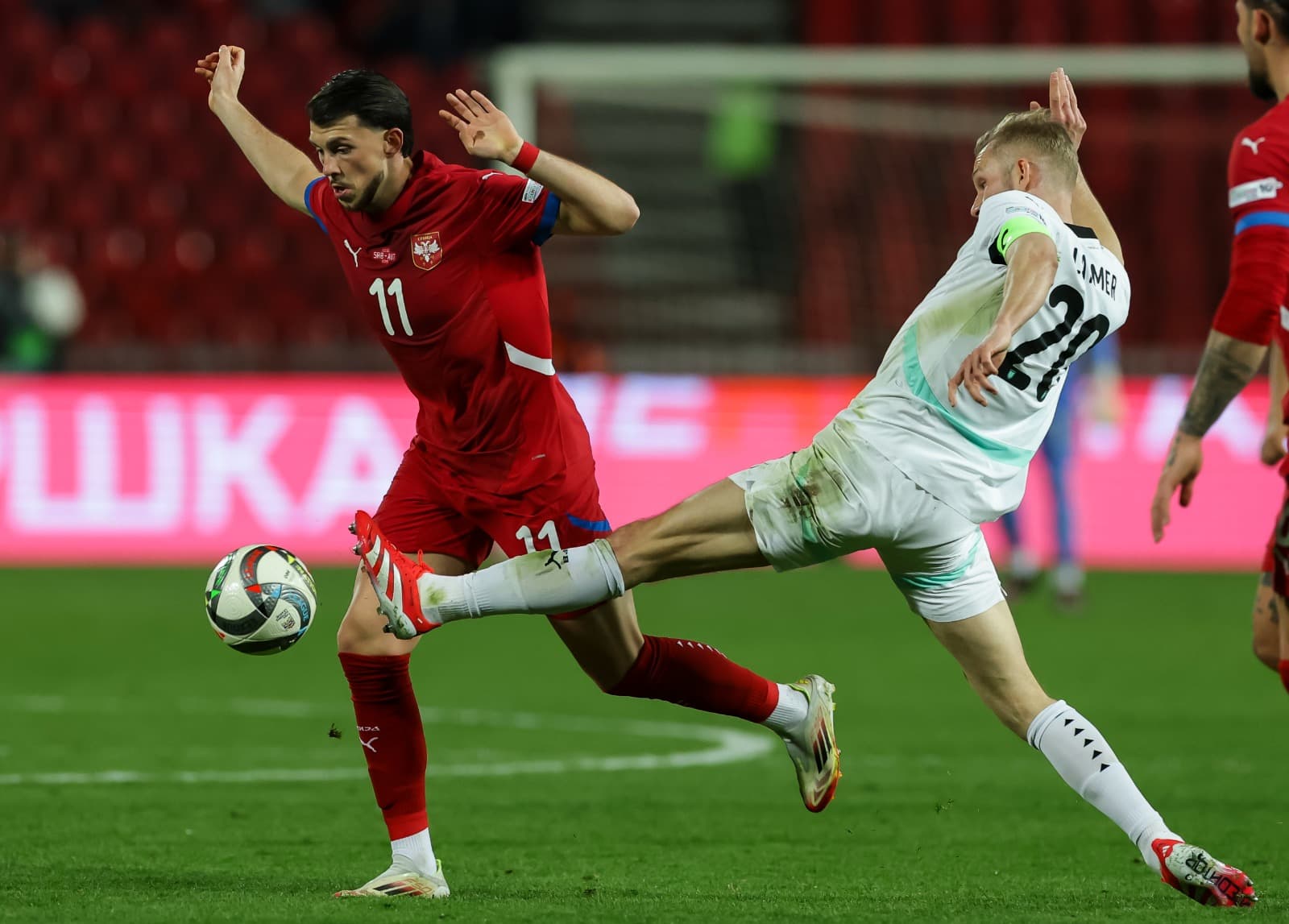 Jogadores de Letônia e Áustria disputam a bola em jogo das Eliminatórias
