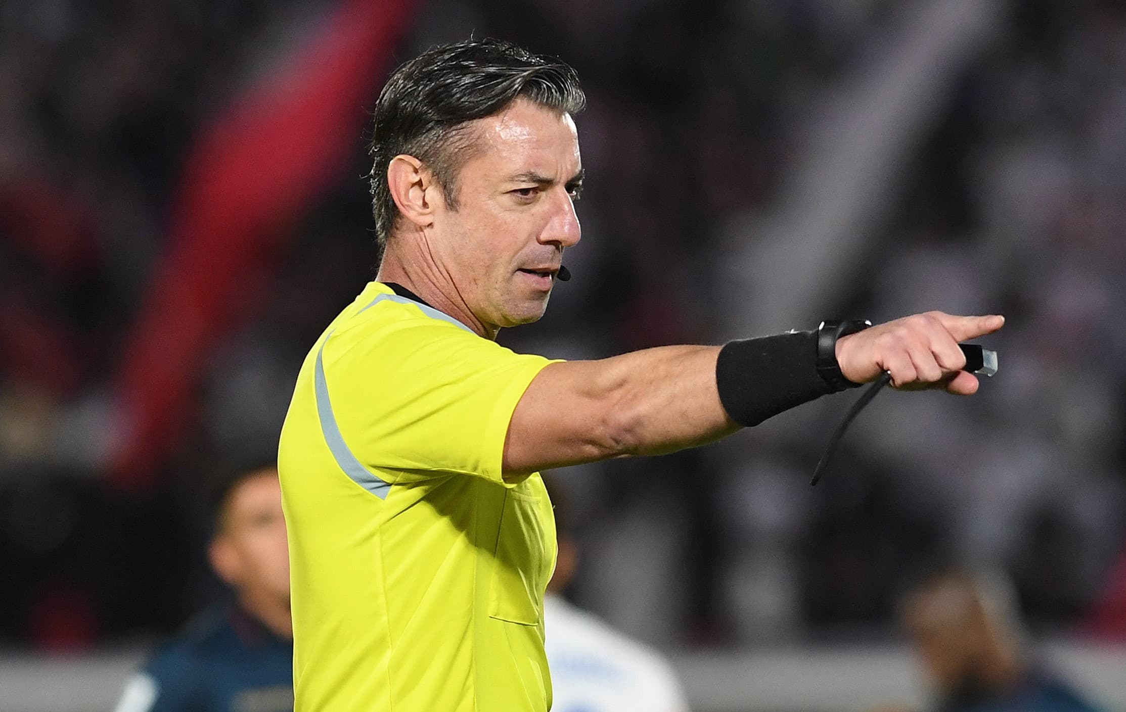 Raphael Claus  aponta para a marca do pênalti em partida das Eliminatórias