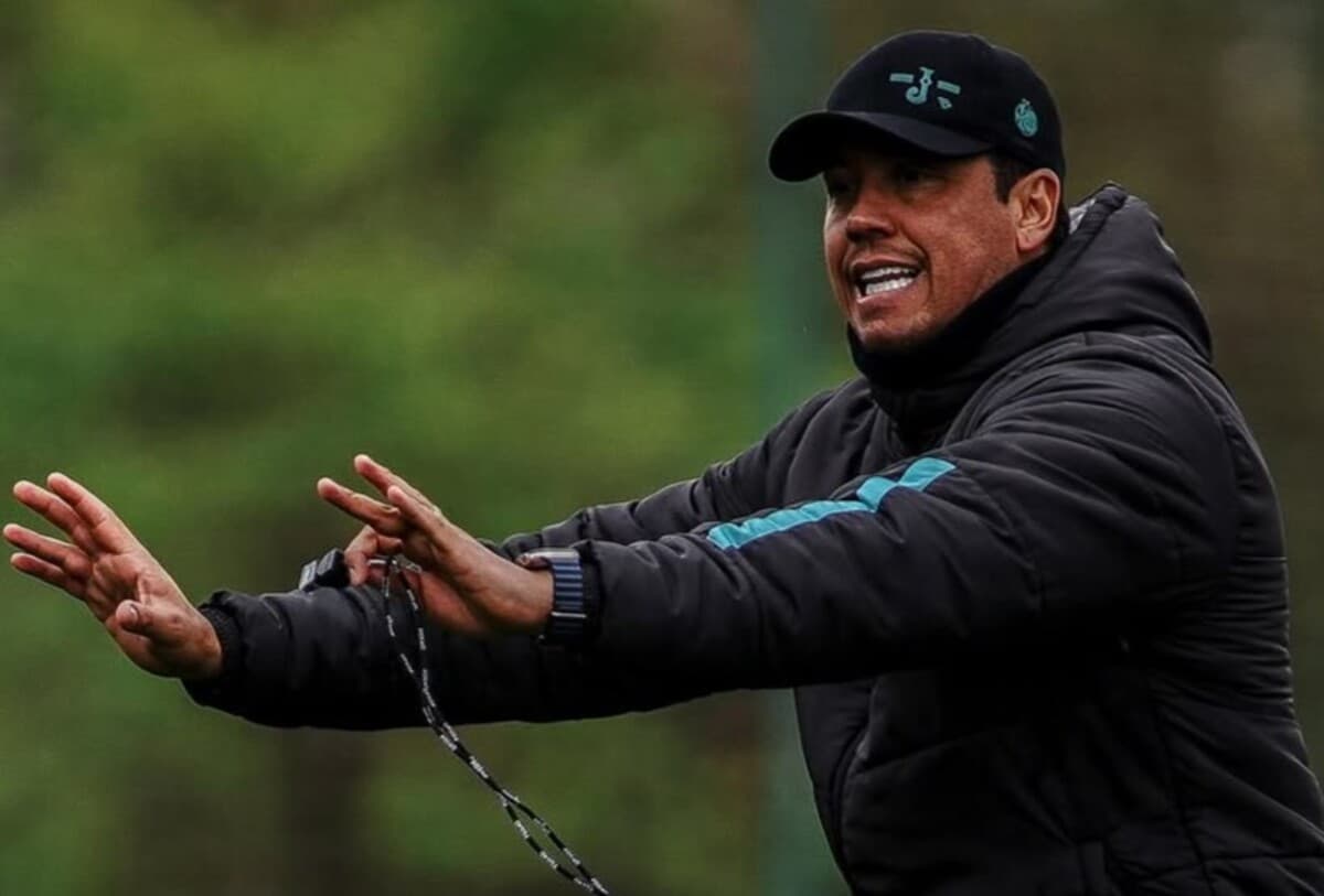 Thiago Carpini estende os braços para a direita ao dar instrução para jogadores do Juventude em treinamento