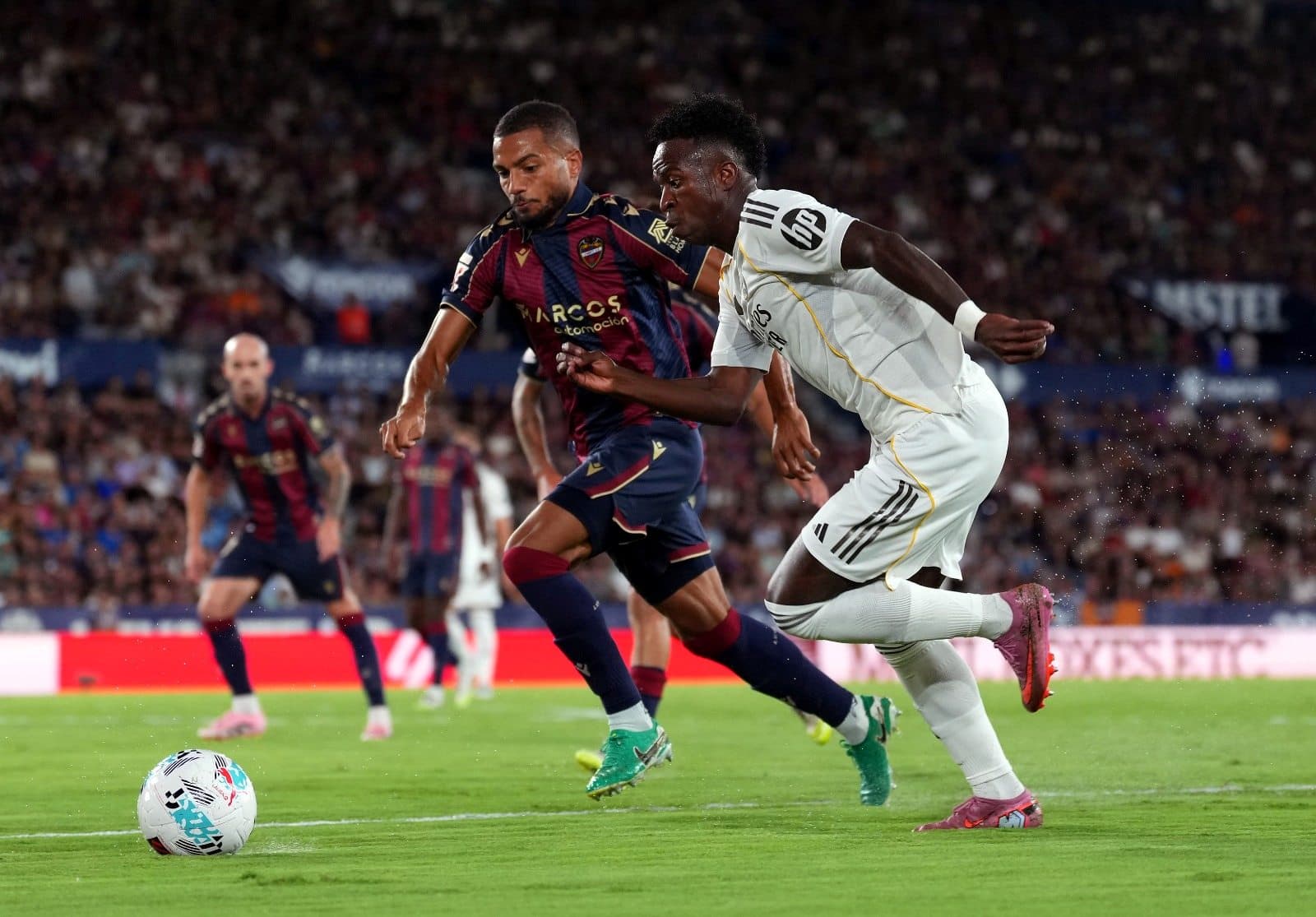 Vinicius Junior, do Real Madrid, disputa a posse de bola com Jeremy Toljan, do Levante UD, durante a partida da LaLiga EA Sports entre Levante UD e Real Madrid CF, na Ciutat de Valencia, em 23 de setembro de 2025, em Valência, Espanha.