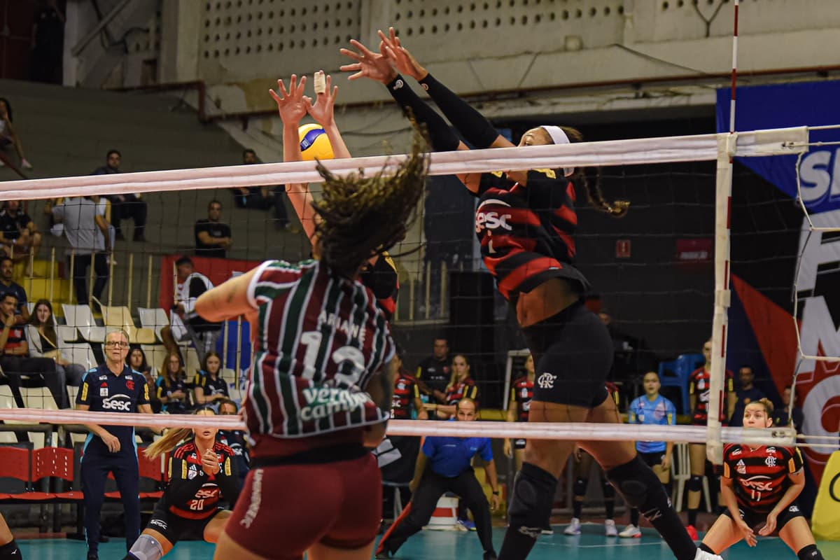 Jogadora do Fluminense salta para tentar ponto contra o Flamengo, enquanto rubro-negra busca bloqueio