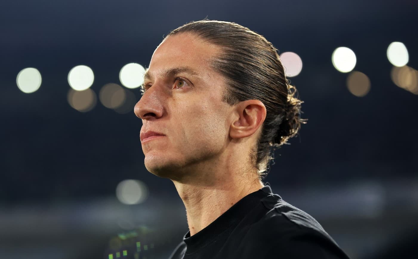 Filipe Luís com expressão séria na beira do campo de jogo do Flamengo