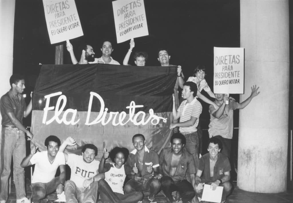 Funcionários do bandejão da PUC com bandeira da Fla Diretas e placas pela Diretas Já