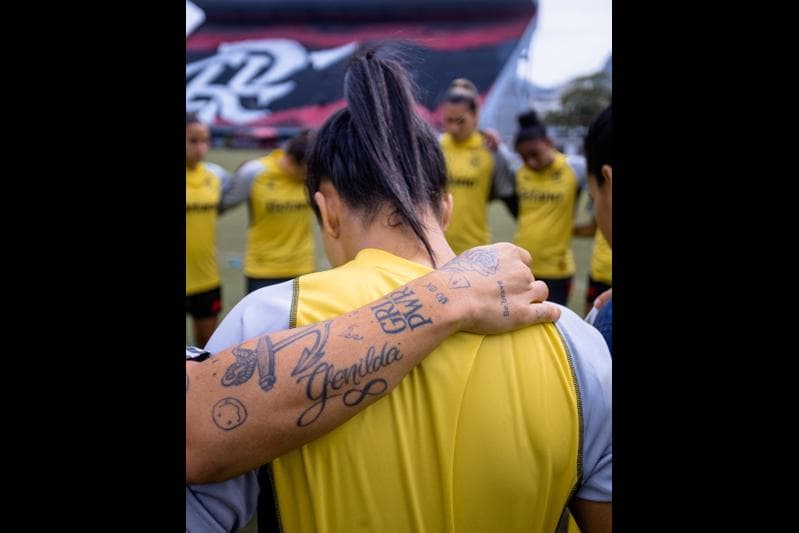 time de futebol feminino do flamengo se concentra como jogadoras abraçadas antes de entrar em campo