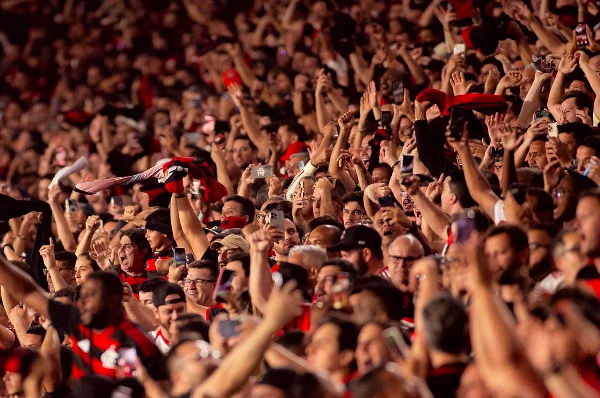 Torcedores do Flamengo erguem os braços e gritam após gol do Flamengo que selou vitória sobre o Racing