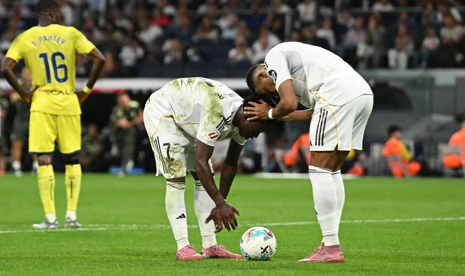 Kylian Mbappe (D), do Real Madrid, conversa com seu companheiro de equipe Vinicius Junior antes de Vinicius converter seu pênalti para marcar o segundo gol do Real durante a partida da LaLiga EA Sports entre Real Madrid CF e Villarreal CF no Estádio Santi