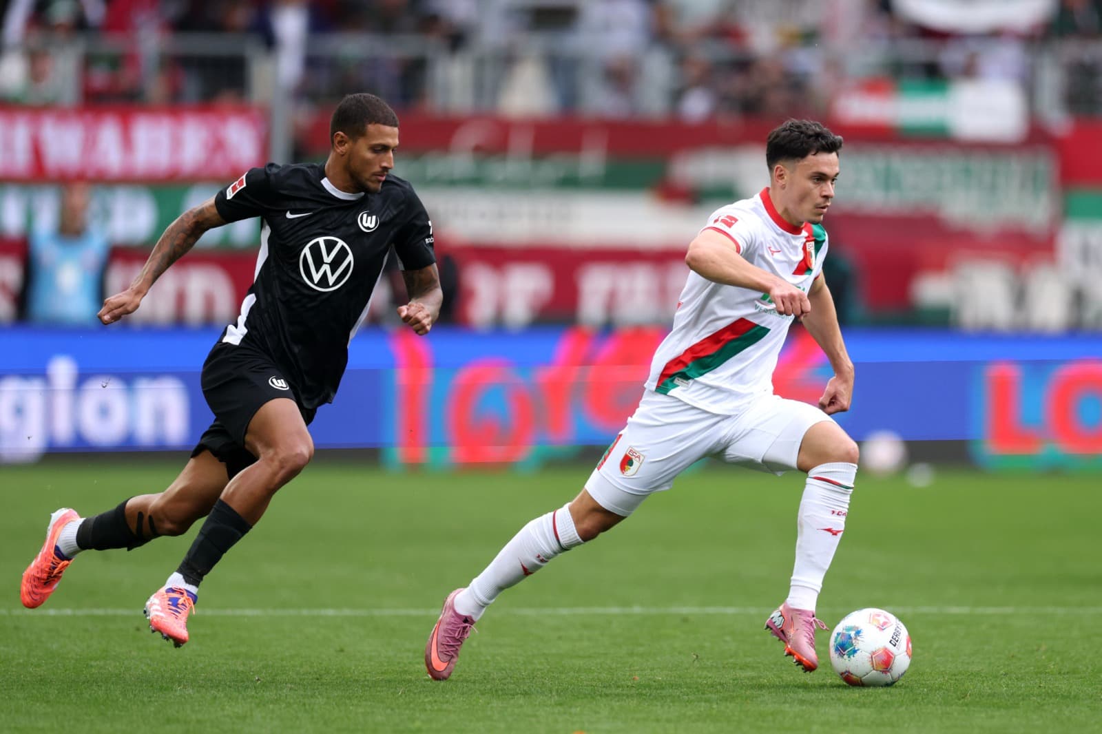 Fabian Rieder, do Augsburg, se separa de Vinicius Souza, do VfL Wolfsburg, durante a partida da Bundesliga entre o FC Augsburg e o VfL Wolfsburg na WWK-Arena em 4 de outubro de 2025 em Augsburg, Alemanha.