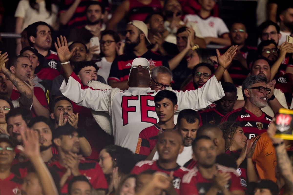 Torcedores do Flamengo apoiam time contra o São Paulo no Maracanã; em destaque, torcedor caracterizado de anjo, olhando para o céu, com "fé" escrito na roupa