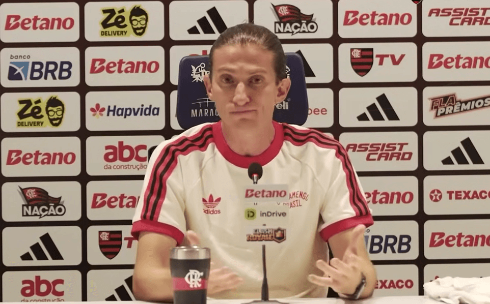 Filipe Luís participa de coletiva de imprensa do Flamengo após a conquista do título brasileiro, falando diante do painel de patrocinadores.
