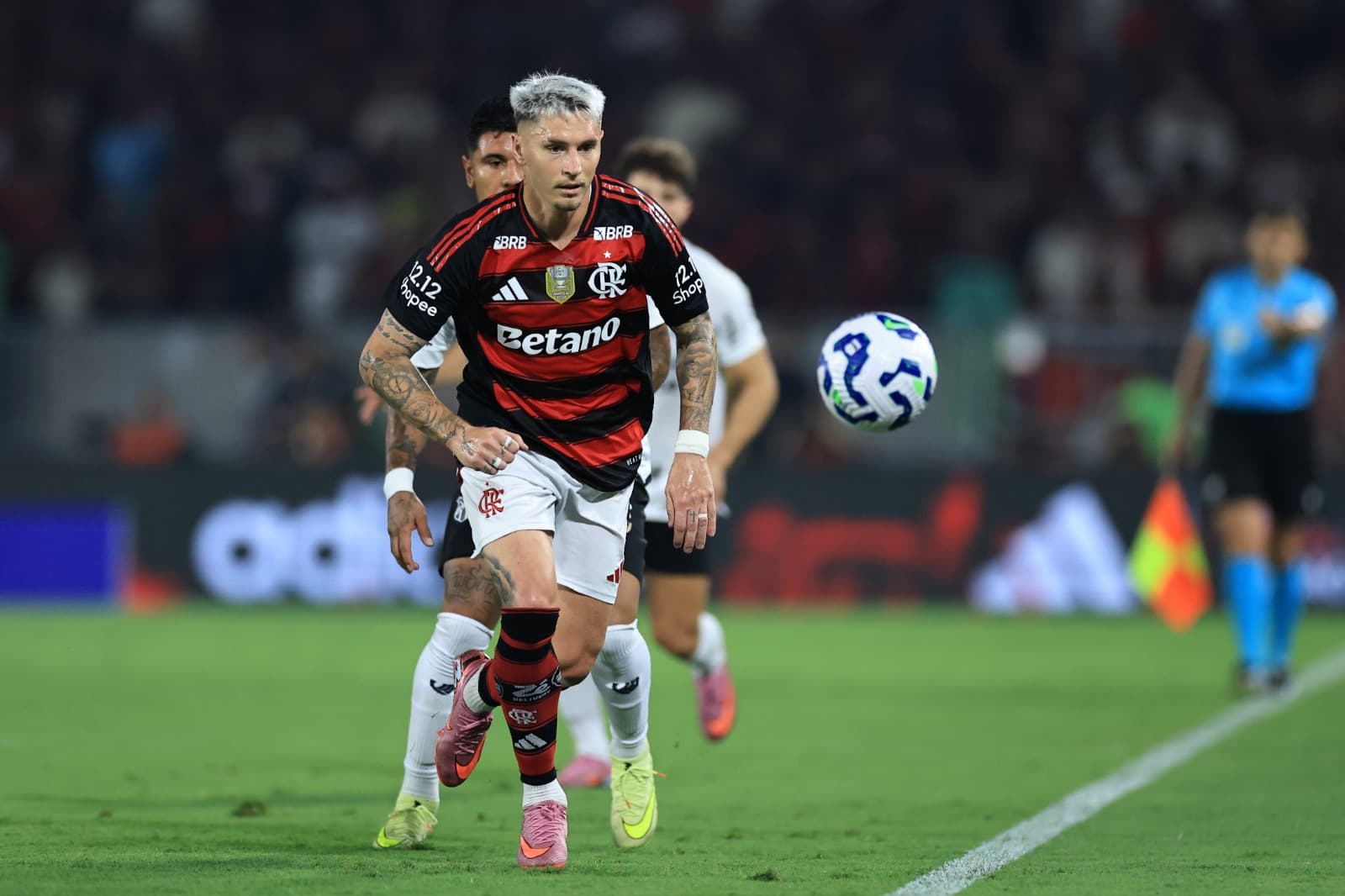 Varela corre para pegar a bola que sai na linha lateral do campo