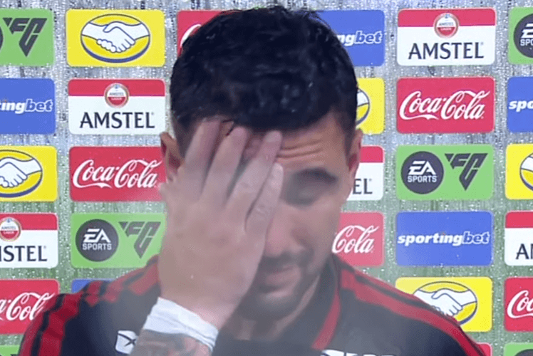 Arrascaeta leva mão ao rosto durante entrevista pós-derrota para o Lanús na Recopa