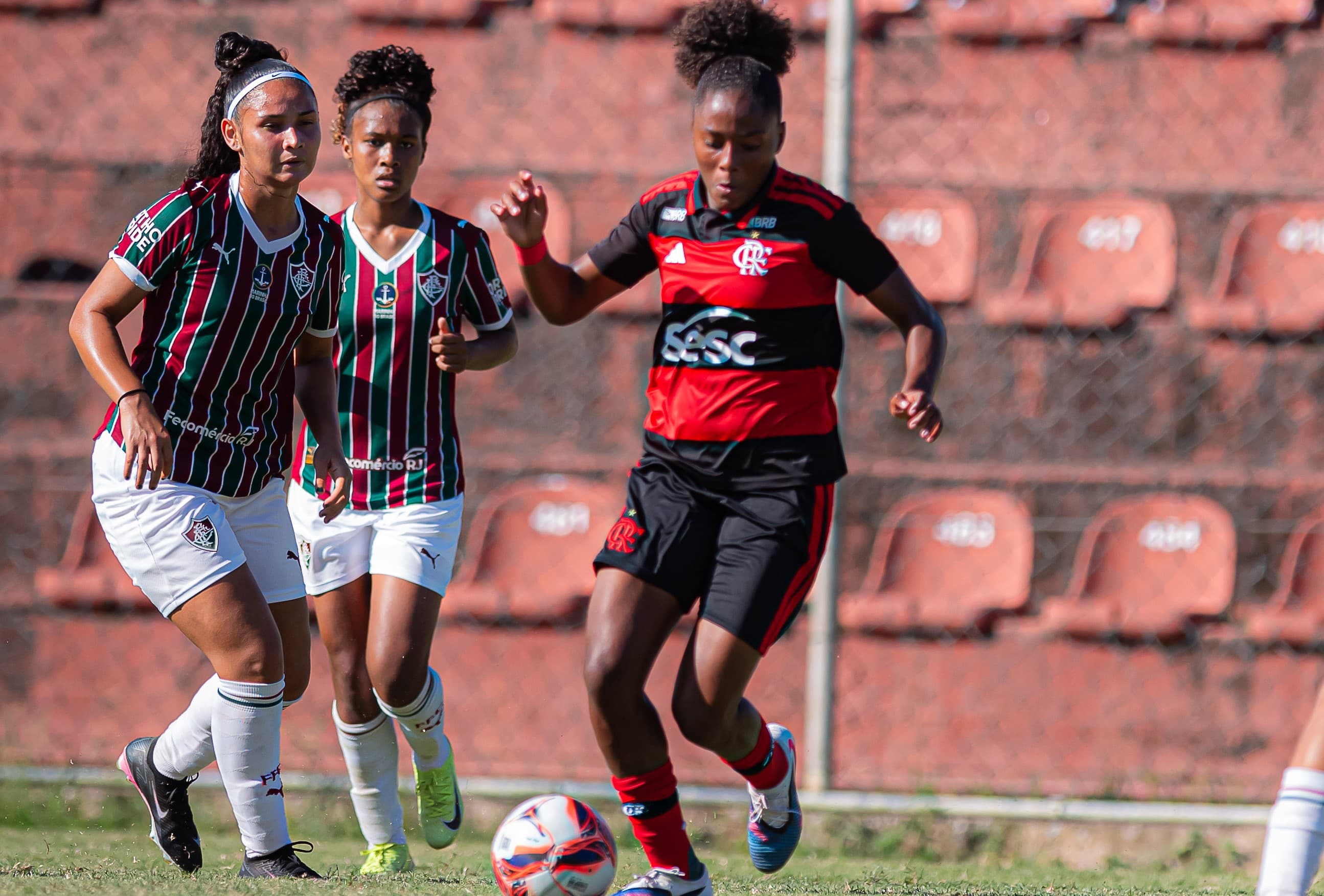 Kaylane carrega a bola enquanto é marcada por jogadoras do Fluminense