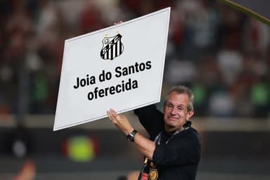 Montagem com Bap segurando um cheque grande, mas ao invés do valor da premiação, tem escrito "joia do Santos oferecida" e o escudo do Santos FC
