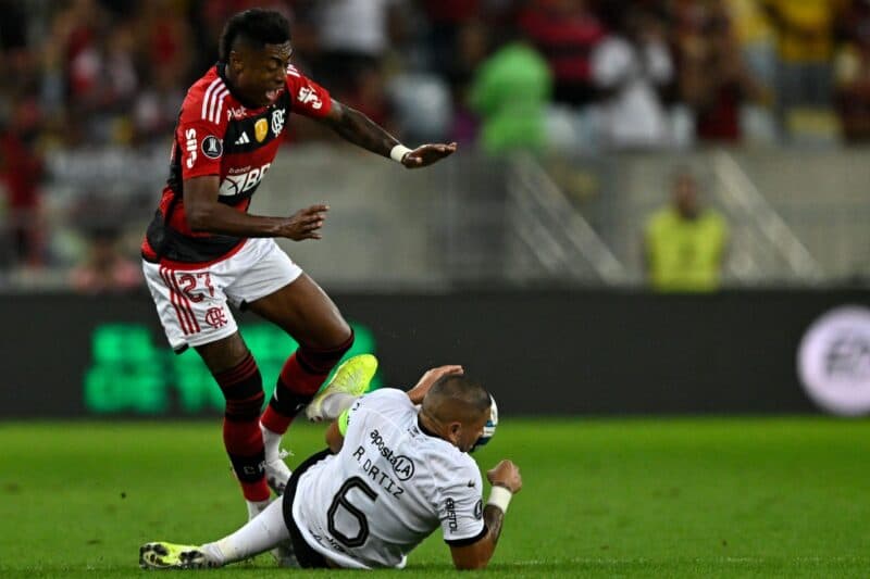 Bruno Henrique marca com assistência de Gabigol em jogo duríssimo pelas oitavas da Libertadores, contra o Olímpia-PAR. Foto: Falta dura que rendeu cartão amarelo para Ortiz.