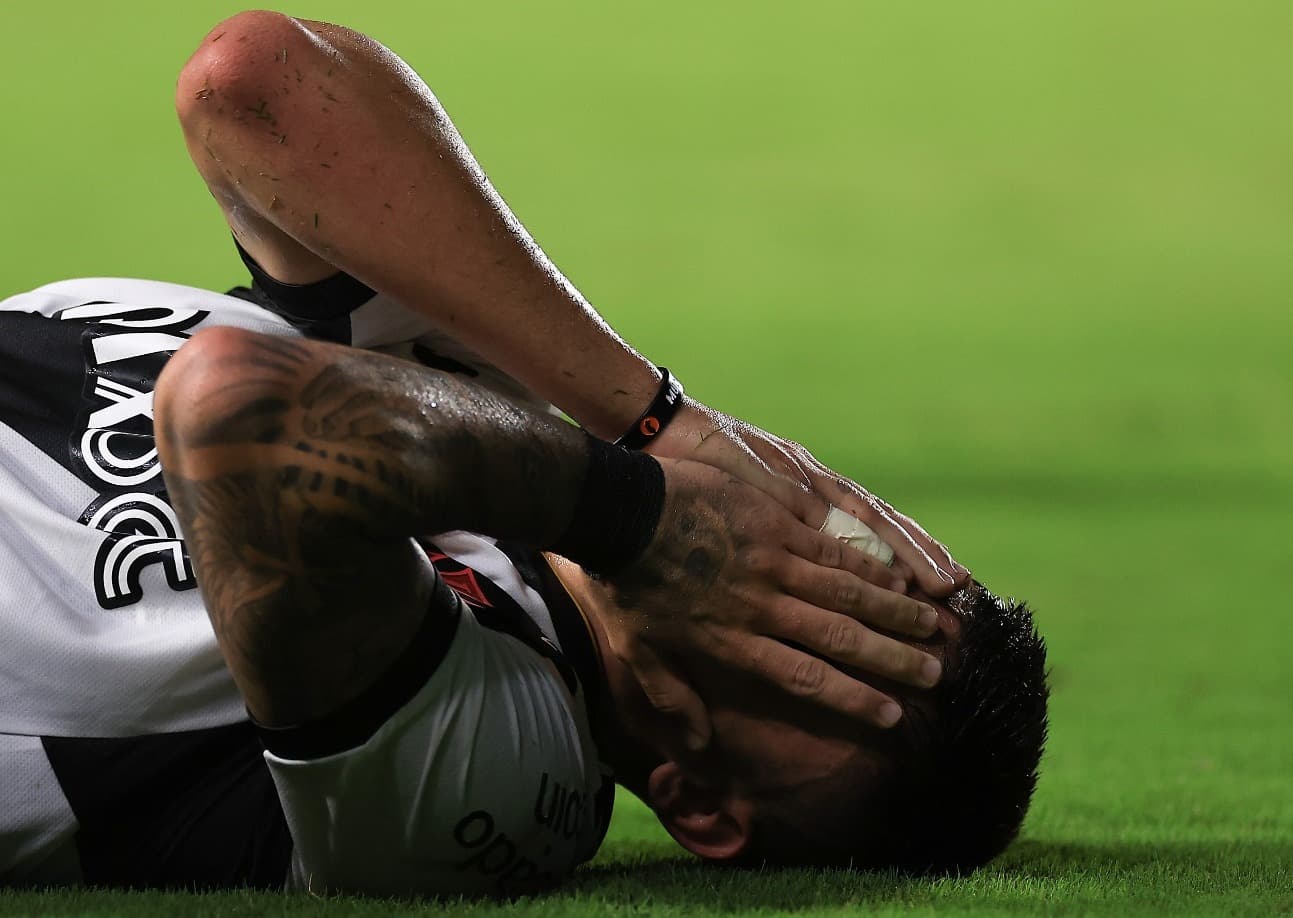 Jogador do Vasco, Gabriel Pec deita no gramado e leva mãos ao rosto