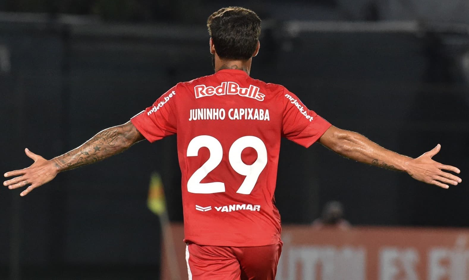 Juninho Capixaba de costas e braços abertos, comemorando gol pelo Bragantino