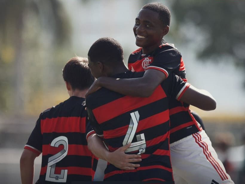 Jogador do Sub-15 do Flamengo sorri ao comemorar gol sendo levantado pelo companheiro