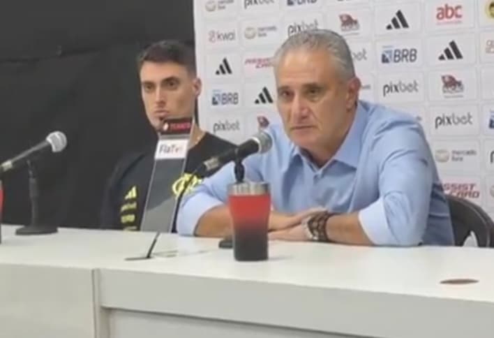 Tite com expressão séria em coletiva ao lado do filho Matheus Bachi