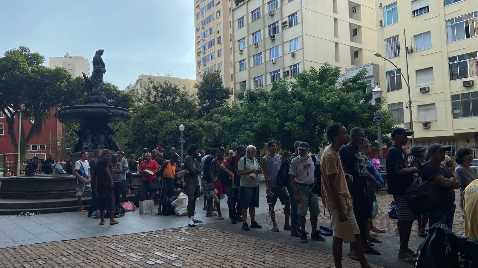 Pessoas em situação de rua formam fila para receberem roupas, água e comida em ação realizada pelo Flamengo próximo ao Natal