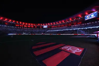 Escudo do Flamengo no gramado Maracanã iluminado com as cores vermelha e preta