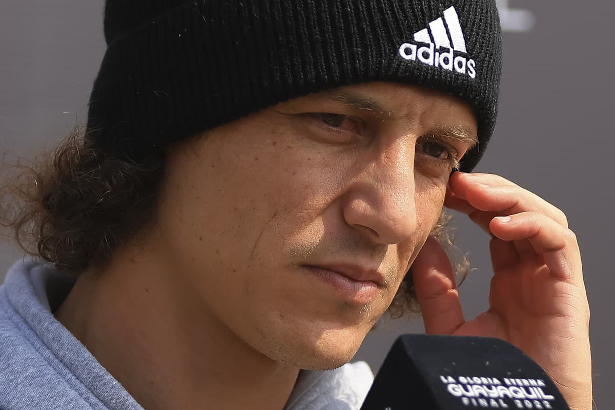 David Luiz concede entrevista com semblante sério, coça o rosto, enquanto usa touca preta da adidas