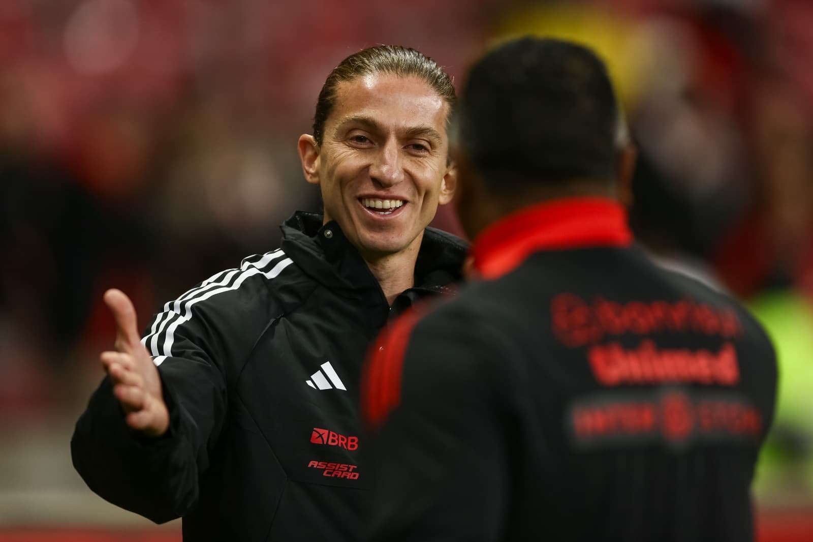 Filipe Luis sorri ao cumprimentar Roger Machado