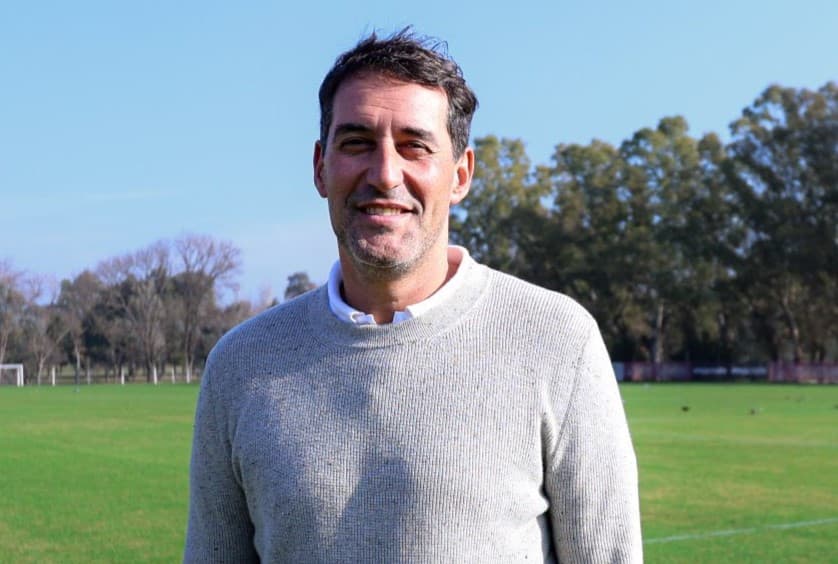 Agustín Alayes, diretor do Estudiantes, sorri em foto no CT do clube