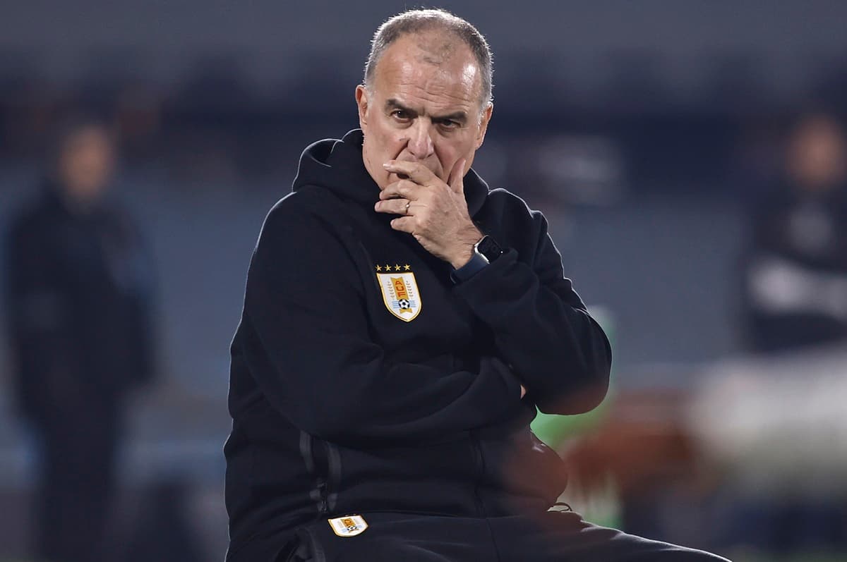 Marcelo Bielsa senta e leva as mãos à boca durante partida do Uruguai, após reclamar bastante com a equipe