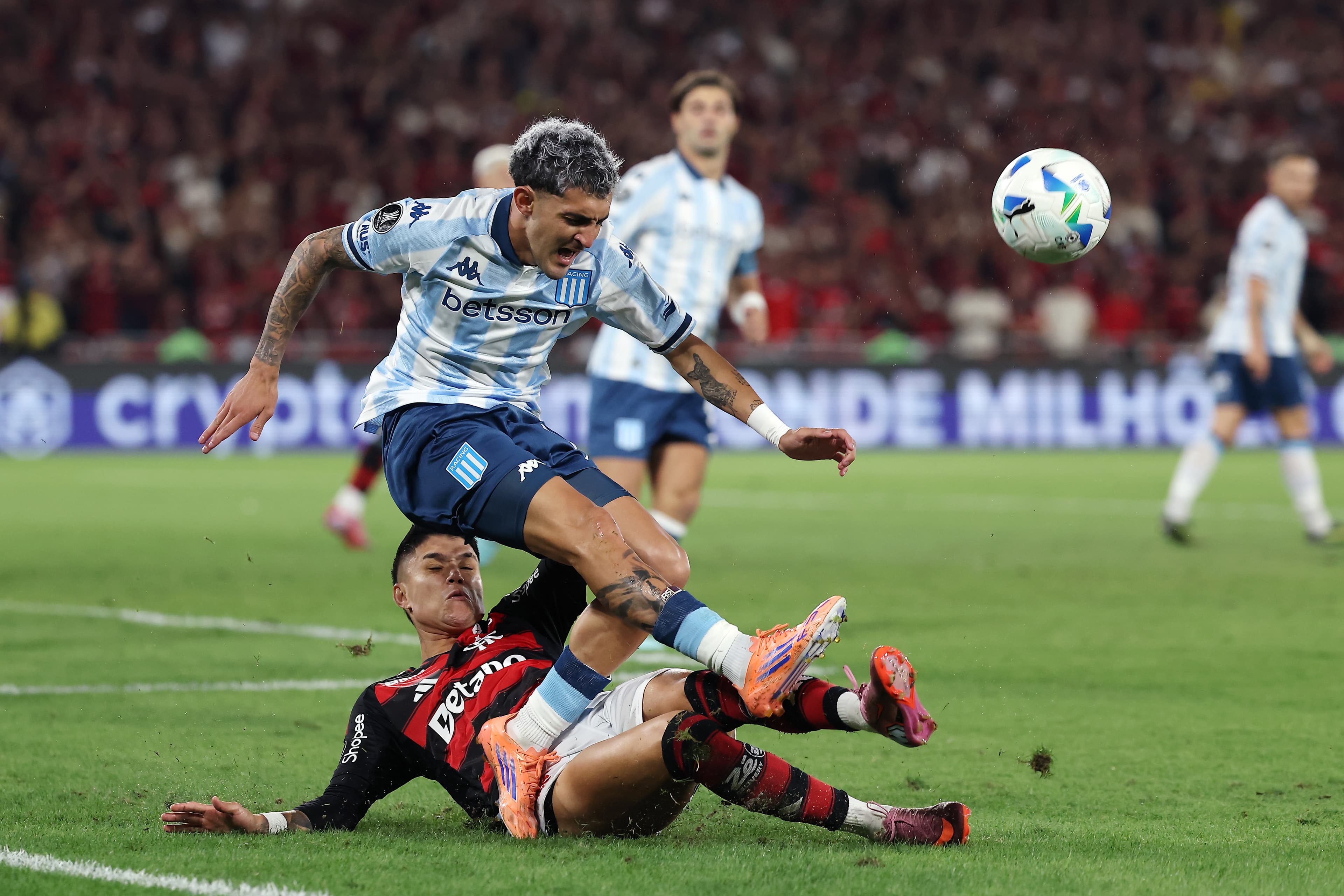 Martirena, lateral do Racing, leva um carrinho por trás do atacante Luiz Araujo, do Flamengo, em duelo entre as equipes na Libertadores