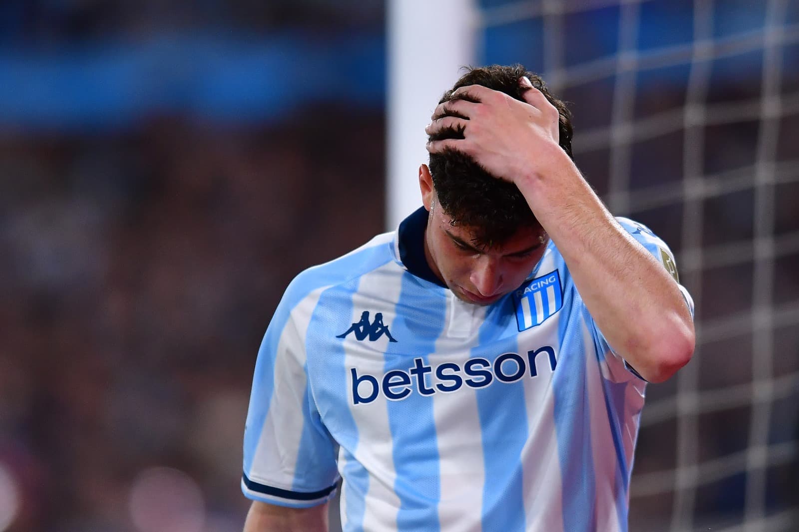 Jogador do Racing leva a mão à cabeça para lamentar chance perdida