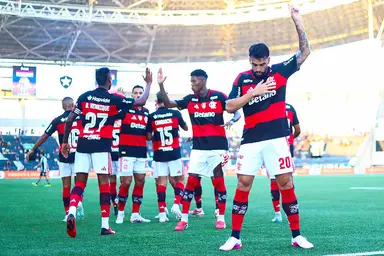 Paquetá comemora gol apontando o dedo para o céu; ao fundo, jogadores se cumprimentam