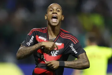 Wallace Yan comemora efusivamente mostrando escudo do Flamengo no uniforme após gol contra o Palmeiras, no Allianz Parque, pelo Brasileirão 2025